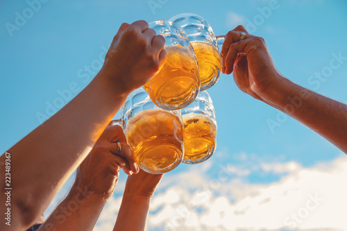 Group of young people enjoying outdoors with beer.