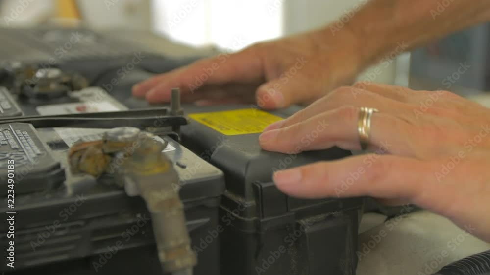 Close up of hands putting case over engine fuse box Close up of hands putting case over engine fuse box