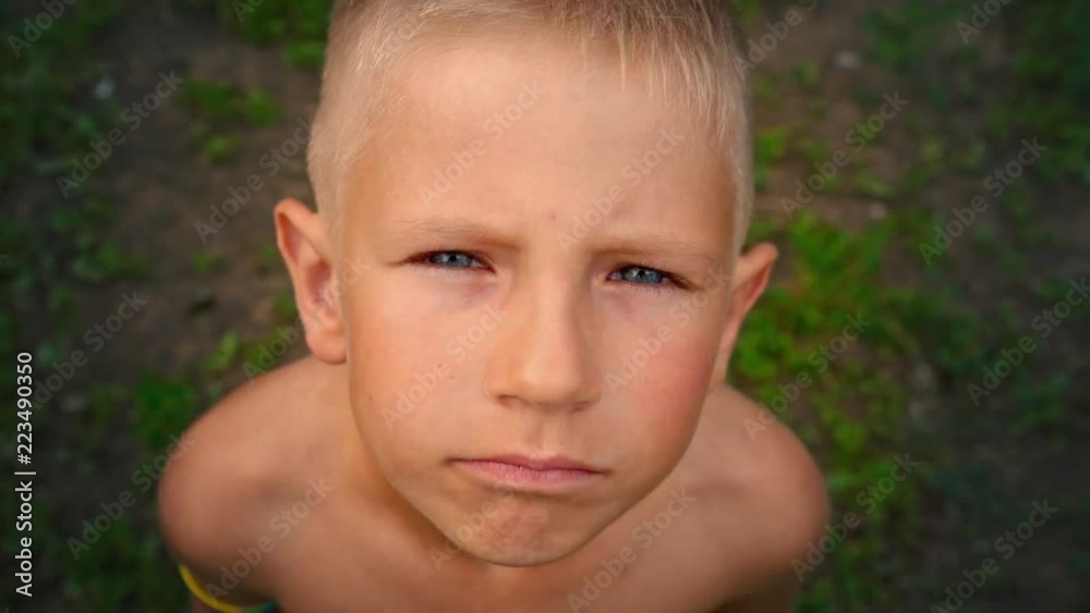 Close-up portrait of a blue-eyed little boy looking and smiling directly at the camera, a piercing look of a 6-year-old child, view from above Close-up portrait of a blue-eyed little boy looking and smiling directly at the camera, a piercing look of a 6-year-old child, view from above