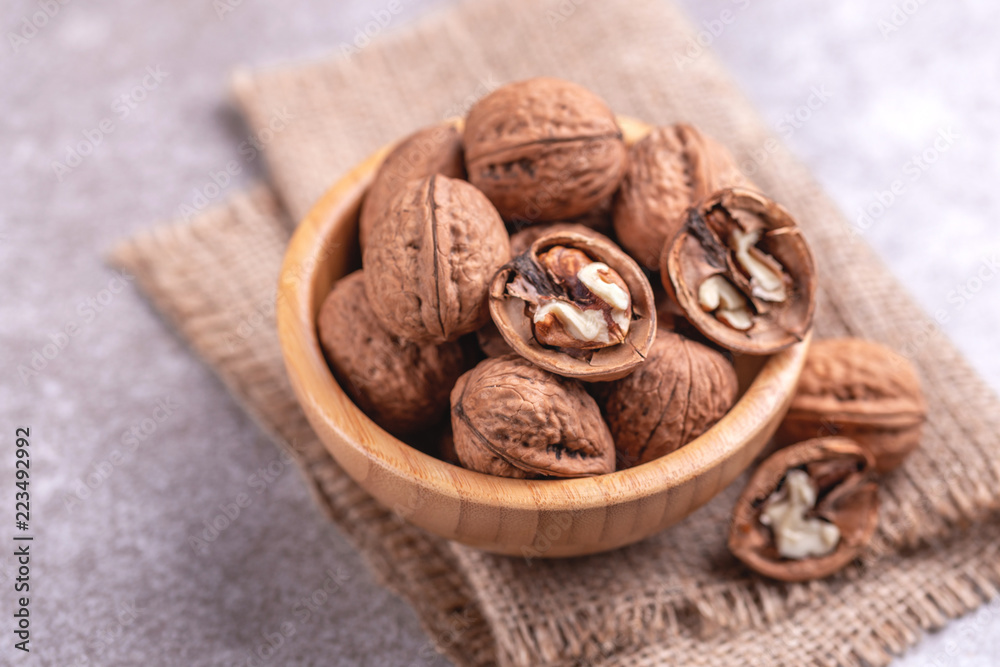 Whole walnuts in wooden bowl. Harvest concept. Whole walnuts in wooden bowl. Harvest concept.
