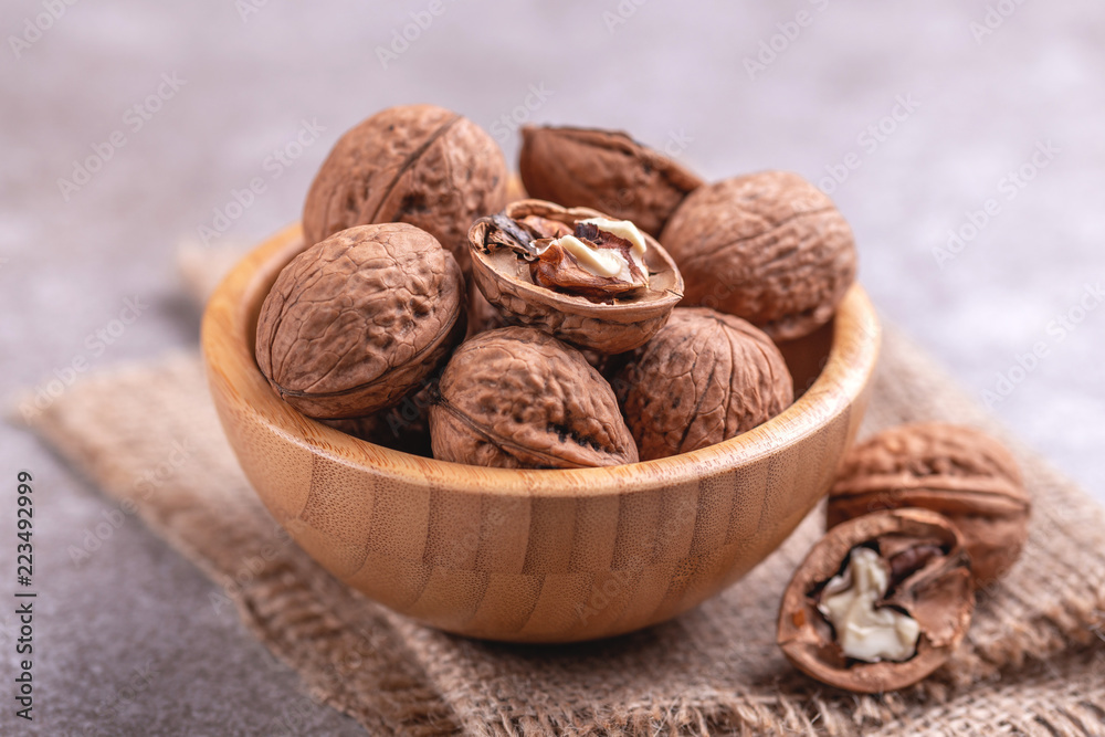 Whole walnuts in wooden bowl. Harvest concept.