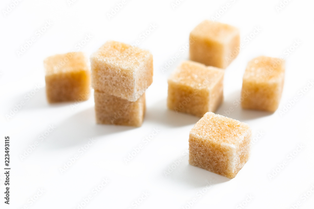 Food Spot focus organic Brown sugar cane cubes on white background Food Spot focus organic Brown sugar cane cubes on white background