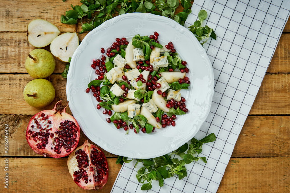 delicious salad of pear gorgonzola cheese and lettuce on a white plate on a wooden table delicious salad of pear gorgonzola cheese and lettuce on a white plate on a wooden table