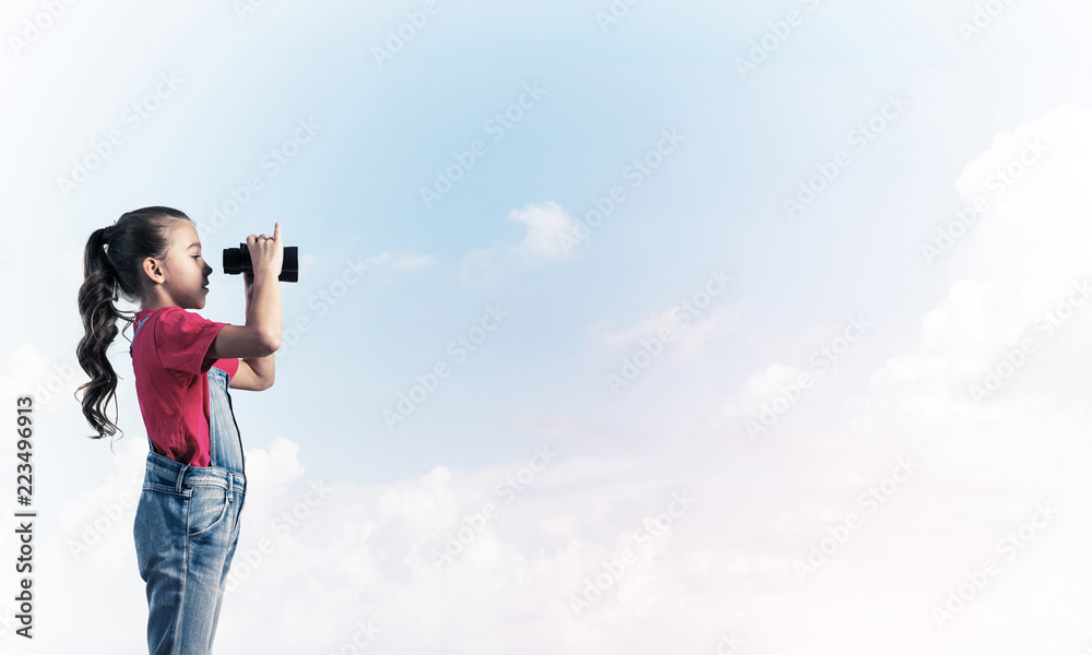 Concept of careless happy childhood with girl looking in binocul Concept of careless happy childhood with girl looking in binocul