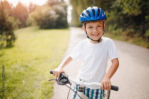 Little boy in helmet learning to ride bicycle park having fun
