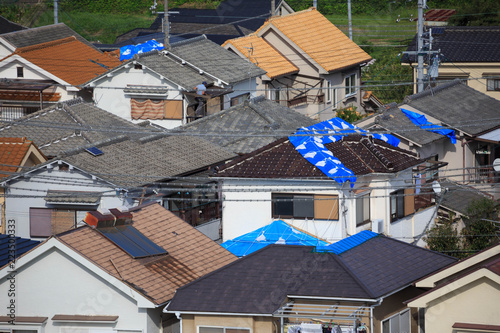 Kumatori, Japan - September 19, 2018: Blue tarps held down with sandbags on roofs damaged when Typhoon Jebi hit Osaka