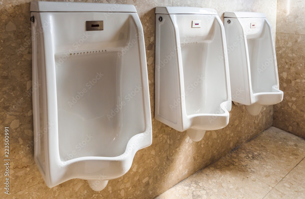 Men's room urinals discharge ,Toilet bowl in a modern bathroom close up Stock Photo Adobe Stock
