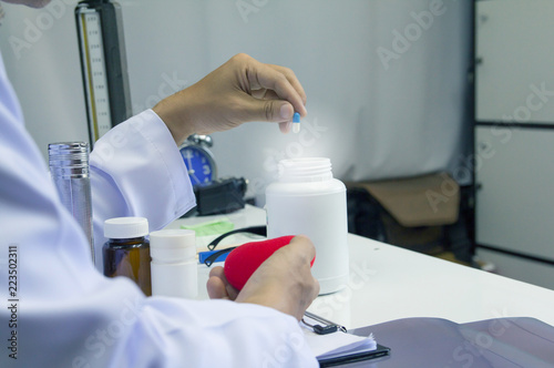 Healthcare and medical concept . Doctor in uniform holding white and blue capsule pill in office at hospital Selective focus