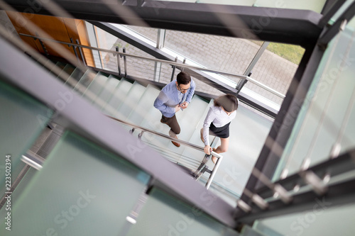 Businessman and Business woman go up the stairs