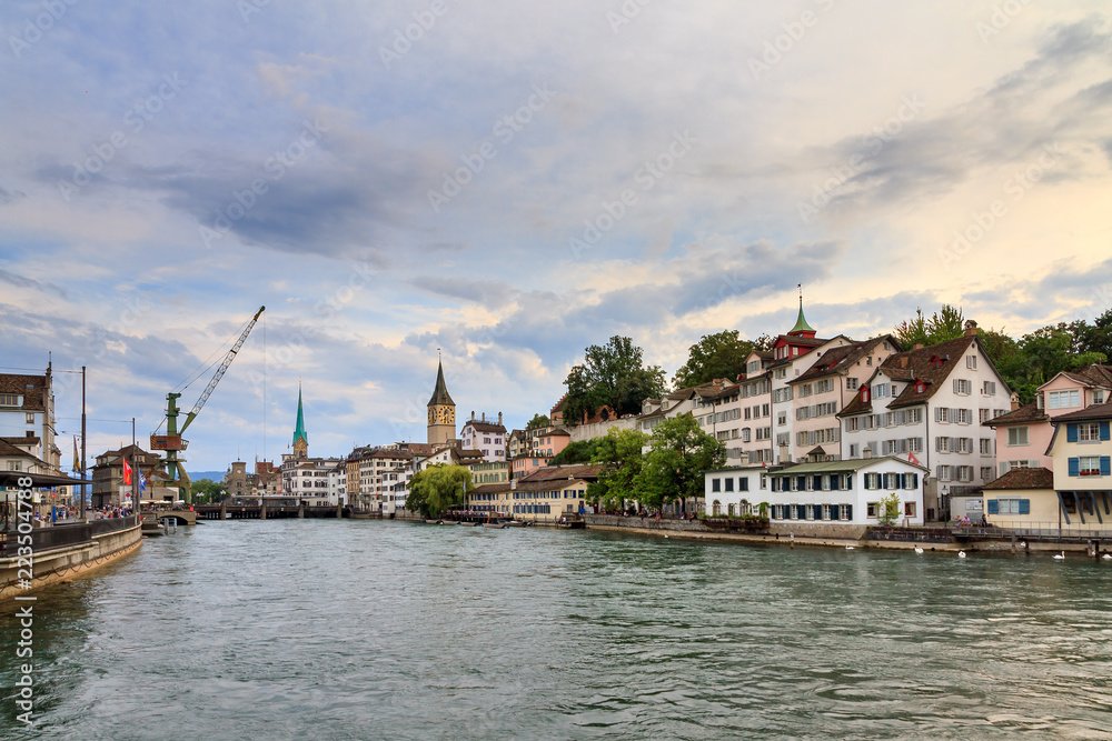 Beautiful summer cityscape of the city Zurich, Switzerland, with the big crane at the river Limmat in the afternoon
