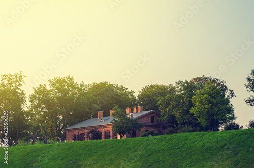 ancient brick house on a hill, trees grow around