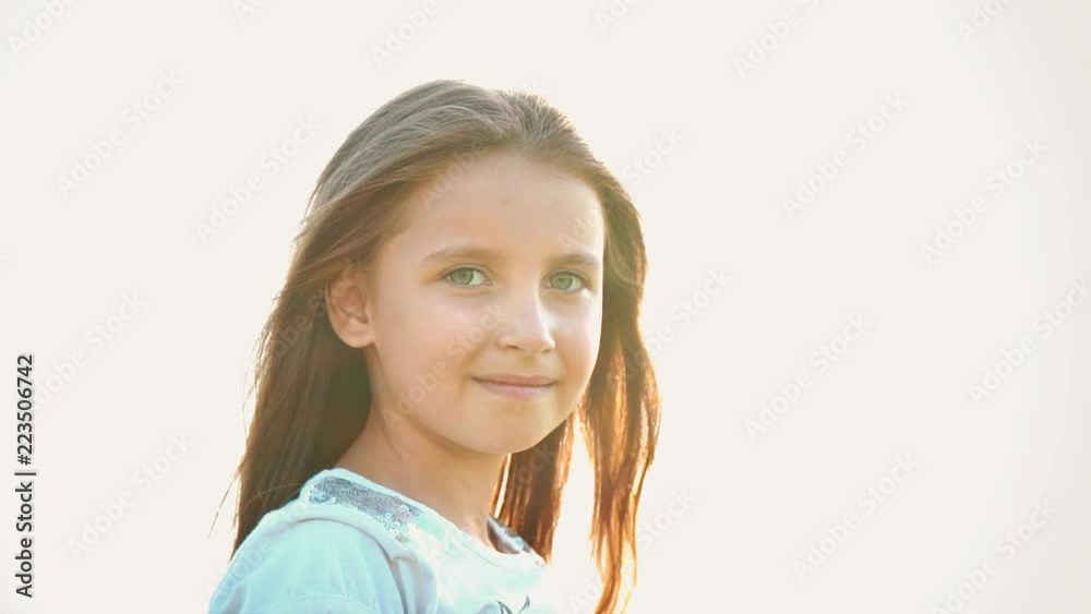 Portrait of attractive little girl with a big green eyes on nature ...