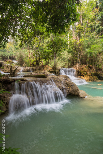 Beautiful view of several small cascades at the Tat Kuang Si Waterfalls near Luang Prabang in Laos on a sunny day.