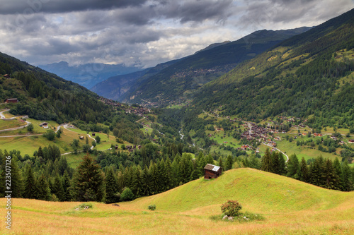 Beautiful view of the Val d’Anniviers valley in Switzerland with the villages saint-luc, saint-jean and vissoie in summer with green fields photo
