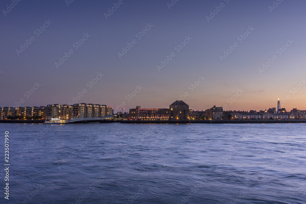 Canary wharf riverside dusk view, London city.