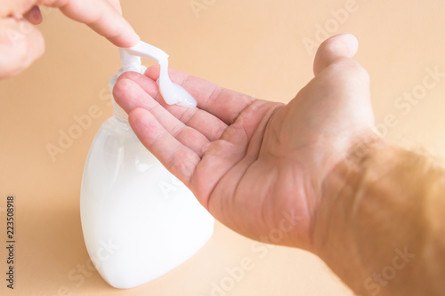 Liquid soap bottle and pressing on the dispenser  soap on the palm. Washing hands.