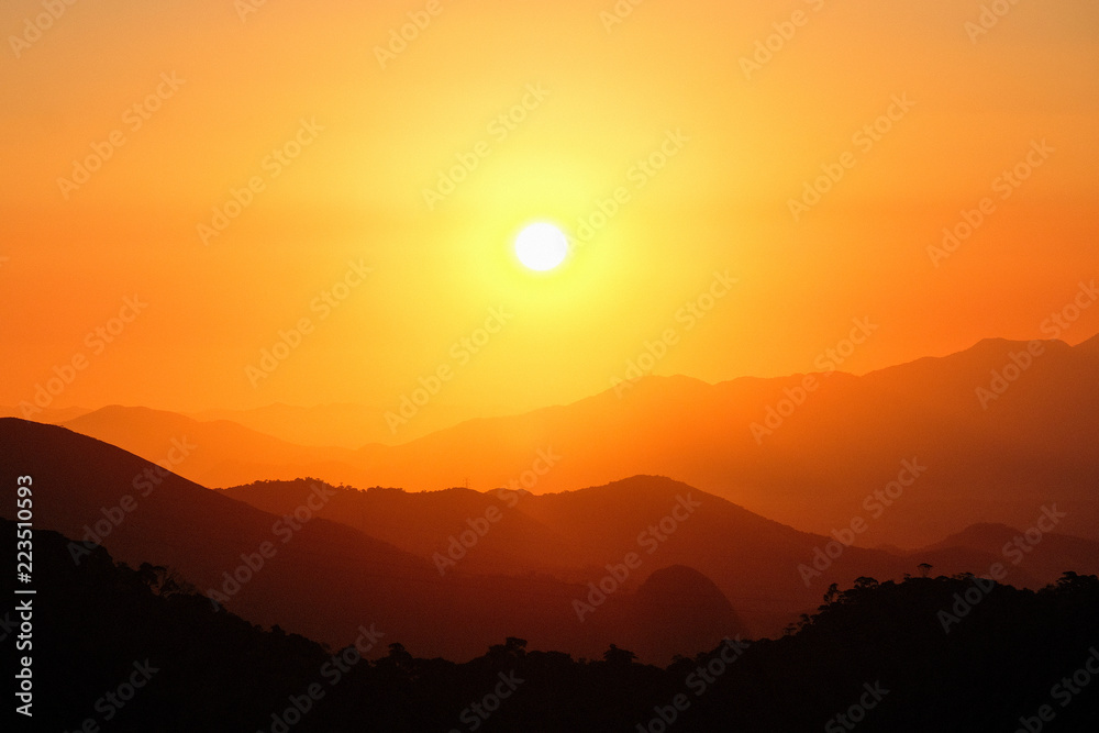 Brazil, Rio de Janeiro. Sunset orange sun and mountains silhouettes