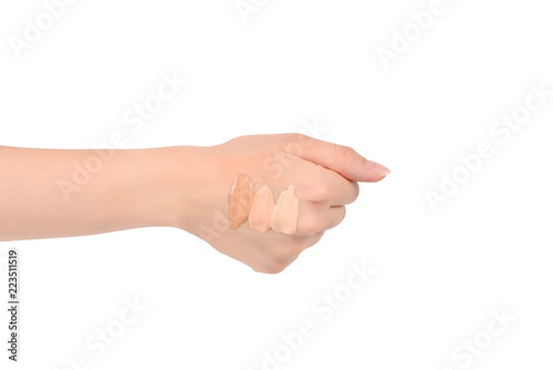 Fair, medium, dark swatches of foundation on the hand isolated on white.