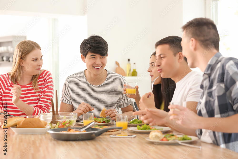Friends eating at table in kitchen