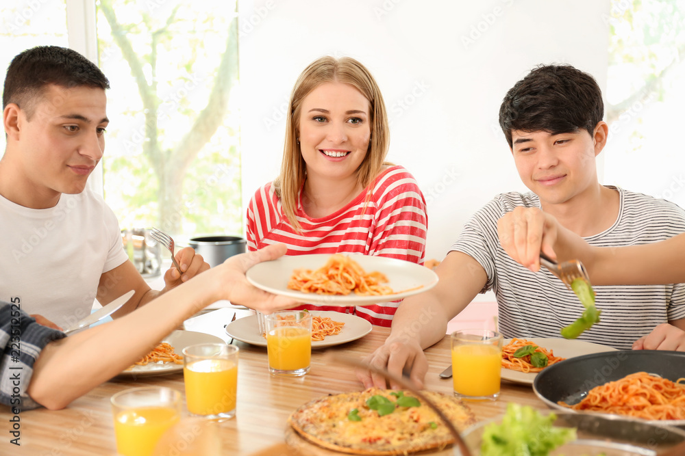 Friends eating at table in kitchen