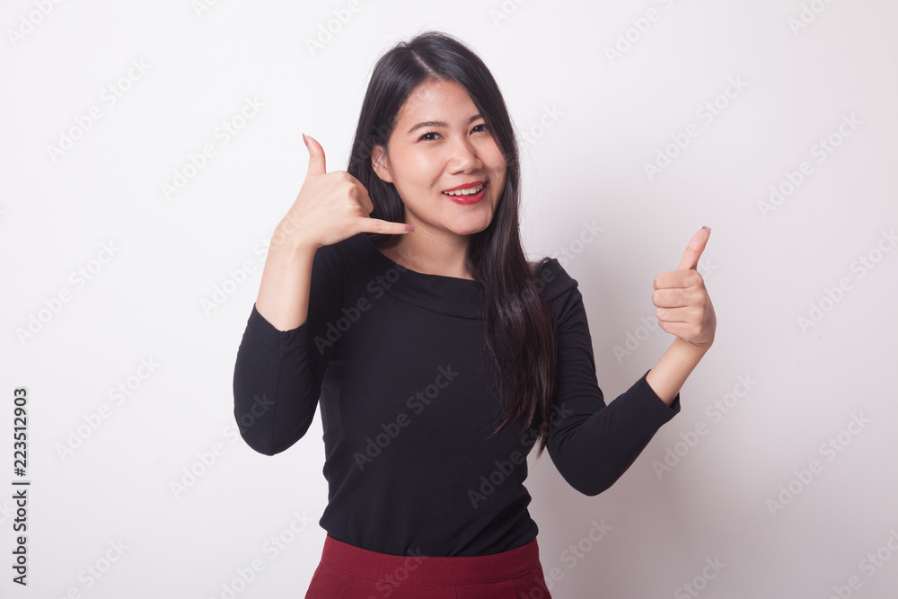 Young Asian woman thumbs up show with phone gesture.