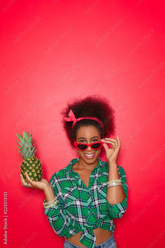 Beautiful African-American woman with pineapple on color background Beautiful African-American woman with pineapple on color background