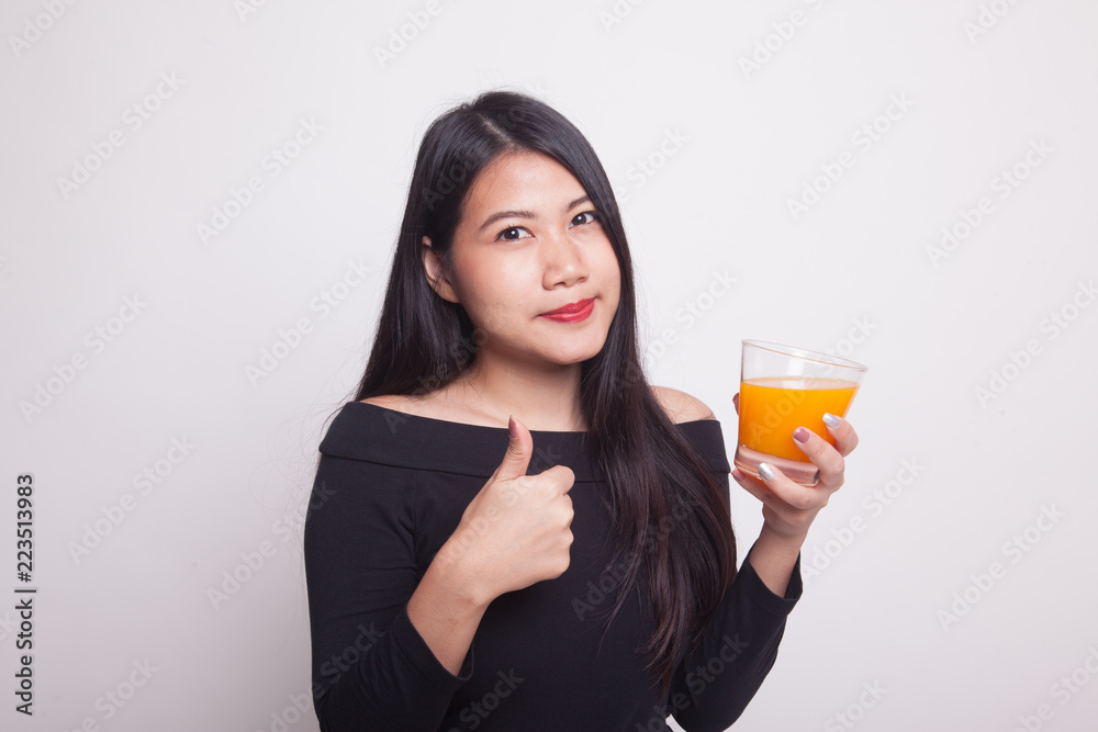 Young Asian woman thumbs up drink orange juice. Young Asian woman thumbs up drink orange juice.