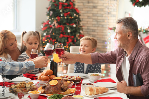 Happy family clinking glasses during Christmas dinner at home