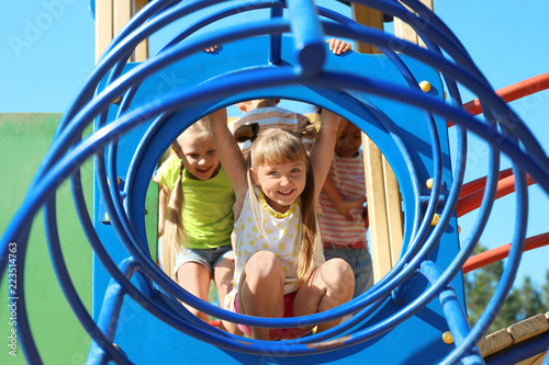 Obraz na płótnie Cute little children having fun on playground outdoors