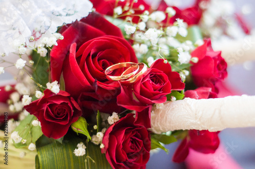 Wedding rings on a bouquet of red roses. Wedding Candles. Bouquet of the bride. Garter of the bride