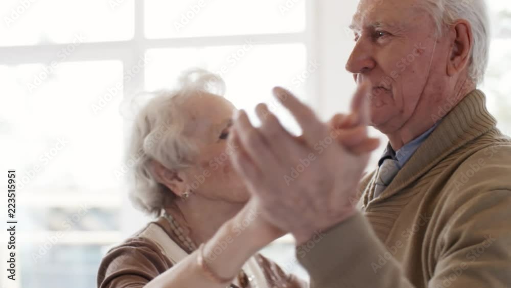 Close-up of romantic senior couple smiling and dancing together at birthday party Close-up of romantic senior couple smiling and dancing together at birthday party