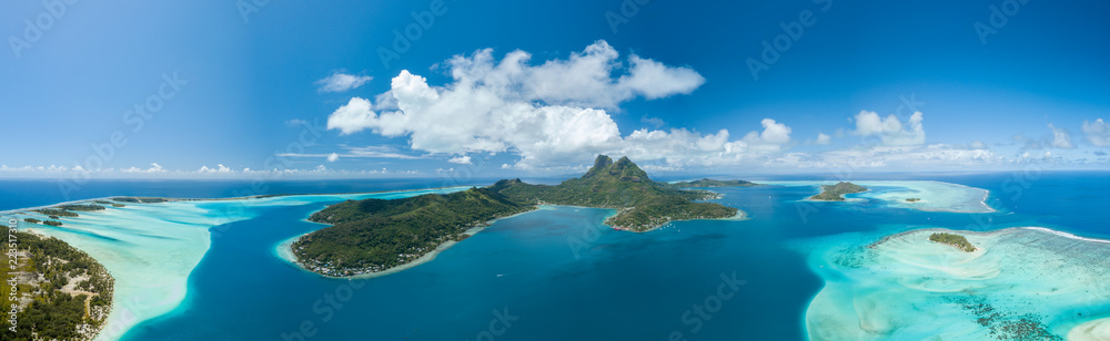 Obraz premium Panoramiczny widok z lotu ptaka luksusowych willi nad wodą z palmami, błękitną laguną, białą piaszczystą plażą i górą Otemanu na wyspie Bora Bora, Tahiti, Polinezja Francuska (Bora Bora Aerial)