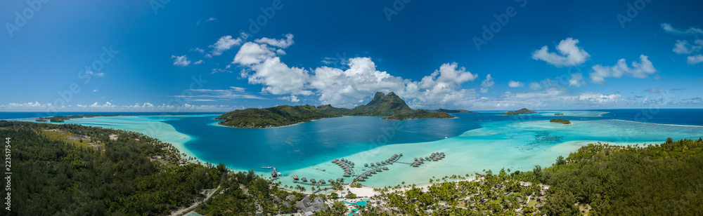 Obraz premium Panoramiczny widok z lotu ptaka luksusowych willi nad wodą z palmami, błękitną laguną, białą piaszczystą plażą i górą Otemanu na wyspie Bora Bora, Tahiti, Polinezja Francuska (Bora Bora Aerial)