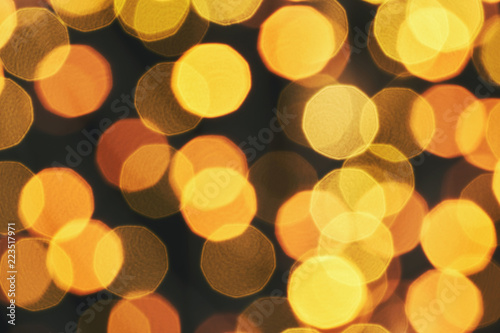 Blur of bright orange lights on a dark background. Christmas texture for greeting cards. A ready-made idea for your design and text. Brilliant background. Bokeh