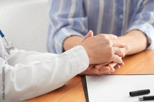 Doctor with female patient after chemotherapy in hospital, closeup