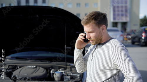 Upset man calling in autoservice after his car broke on the parking lot.