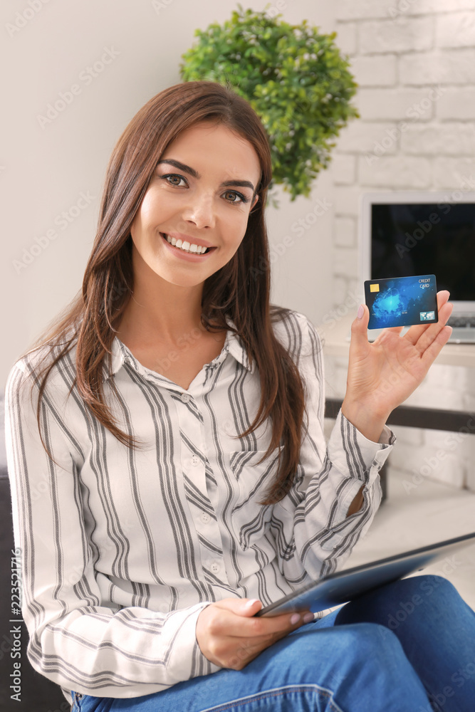 Young woman shopping online with credit card and tablet PC at home Young woman shopping online with credit card and tablet PC at home