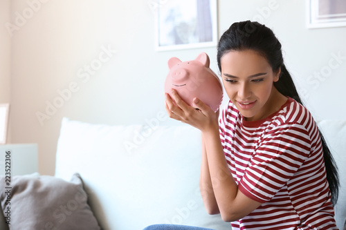 Young woman with piggy bank...