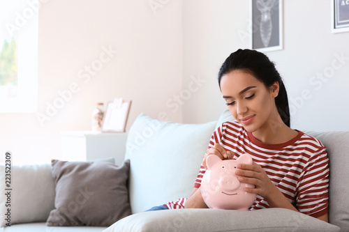 Young woman putting money i...