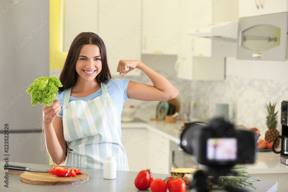 Young female food blogger recording video in kitchen Young female food blogger recording video in kitchen