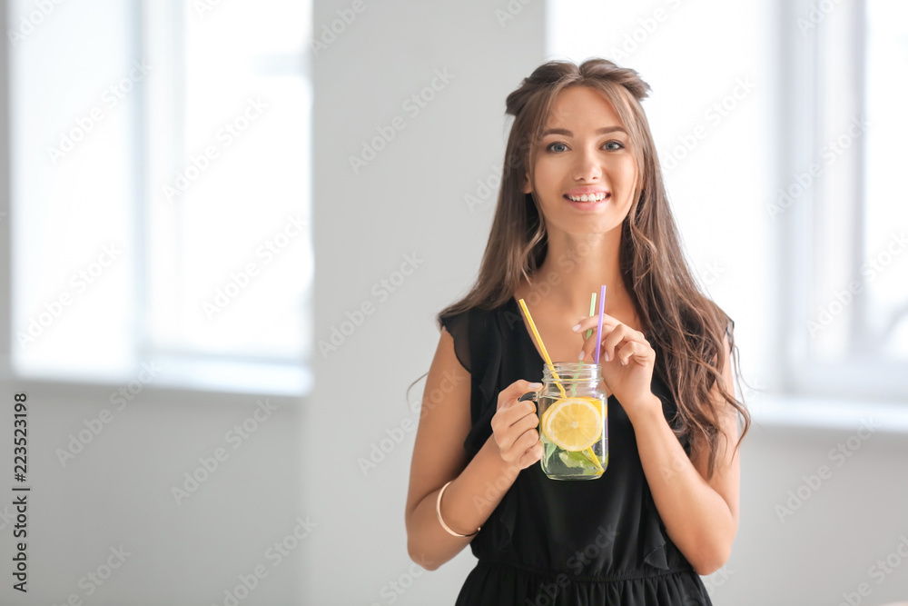 Young woman with mason jar of fresh lemonade at home Young woman with mason jar of fresh lemonade at home