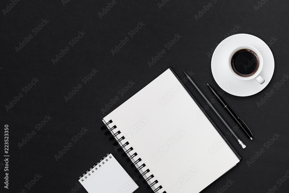 Minimal workplace with blank notepad, coffee cup and and supplies on black surface. Top view with copy space for input the text. Flat lay Minimal workplace with blank notepad, coffee cup and and supplies on black surface. Top view with copy space for input the text. Flat lay