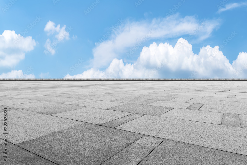 Empty stone floor under blue sky and white clouds