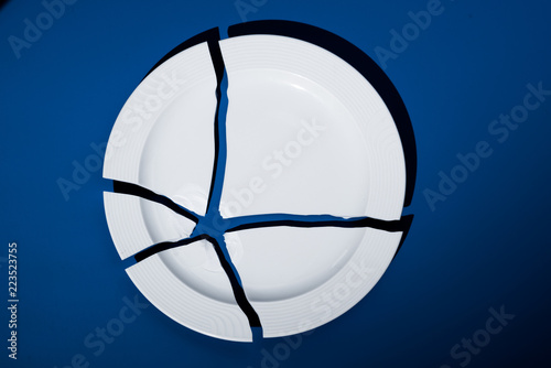 Canvastavla broken porcelain plate on a blue background