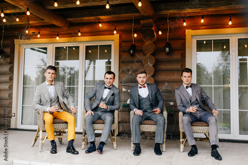 The groom and his groom's friends are sitting on the terrace of the house