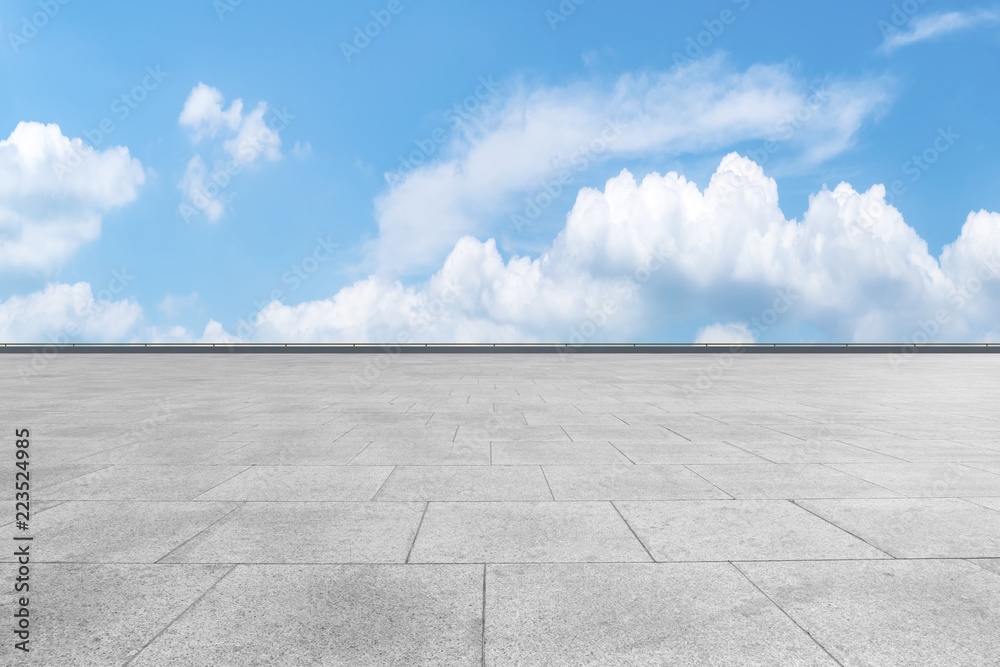 Empty stone floor under blue sky and white clouds