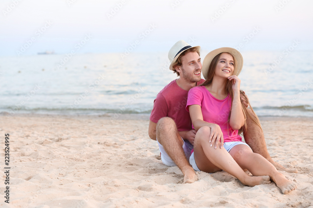 Happy young couple resting on sea beach