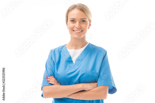 smiling young nurse with crossed arms looking at camera isolated on white photo