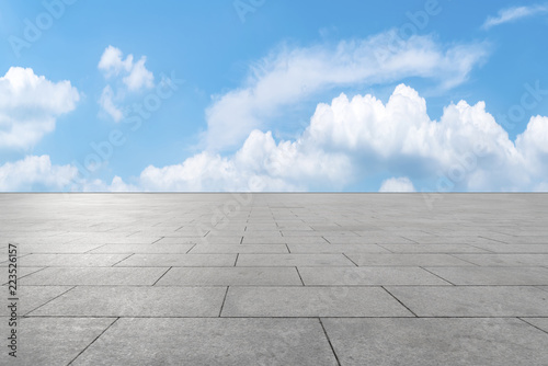 Empty stone floor under blue sky and white clouds