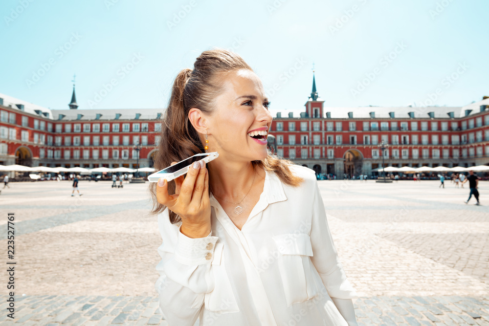 Fototapeta premium szczęśliwa turystyczna kobieta słuchając audioprzewodnika na smartfonie